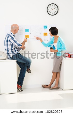 Vertical image of business partners working out strategy of company together