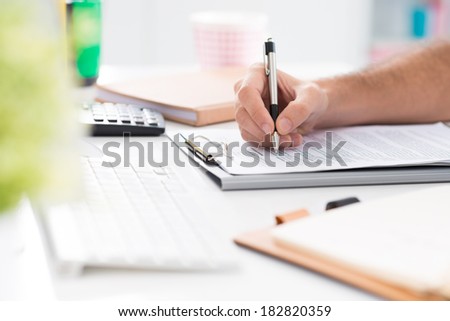 Human hand writing business review on the foreground