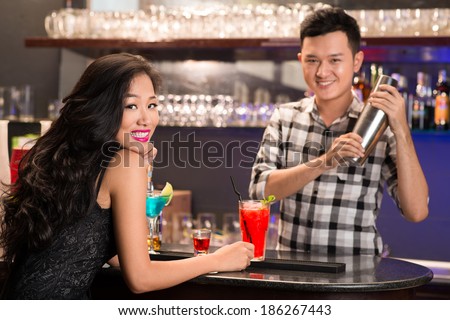 Asian barmen serving drinks to the woman