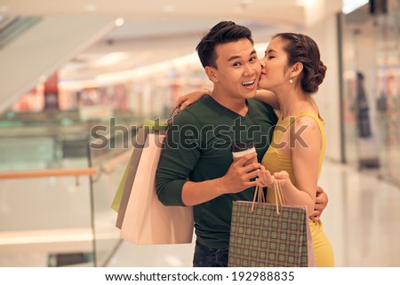 Asian woman kissing her boyfriend in the store