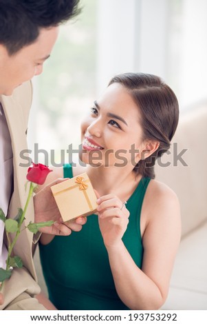 Man giving a present and rose to his girlfriend