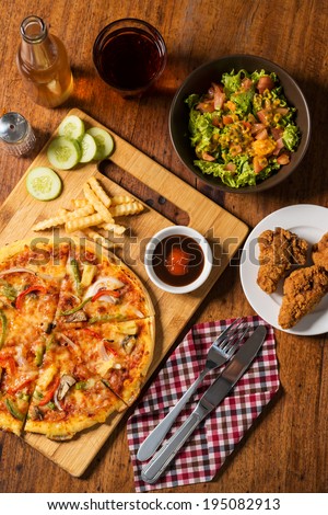 Homemade pizza, salad and fried chicken ready to eat