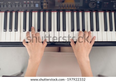 Female piano player, view from the top, body and buttons of the piano were digitally modified