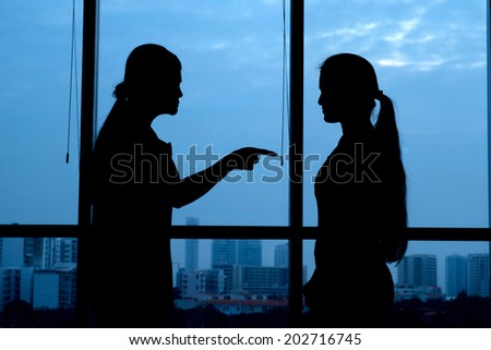 Silhouette of woman punishing her teenage daughter: generation conflict