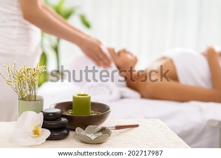 Spa accessories and a woman receiving spa treatment in the background