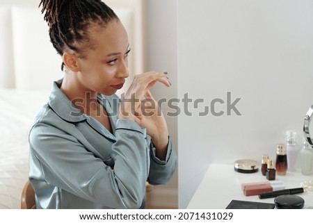 Similar – Image, Stock Photo Cheerful black woman smelling aromatic flower in hothouse