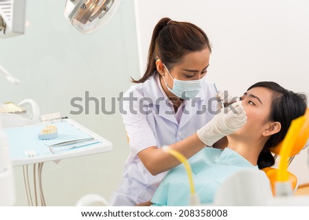 Vietnamese female dentist examining a patient