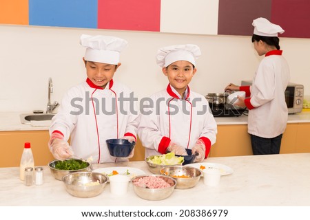 Group of Vietnamese children cooking in the kitchen