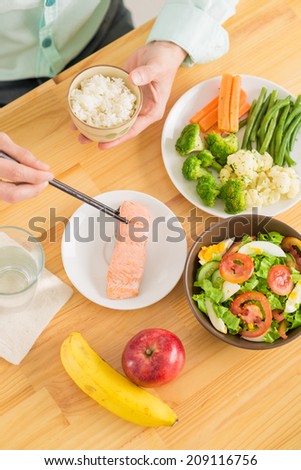 Man eating rice and fish with chopsticks