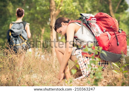 Young woman lacing up shoes before go hiking