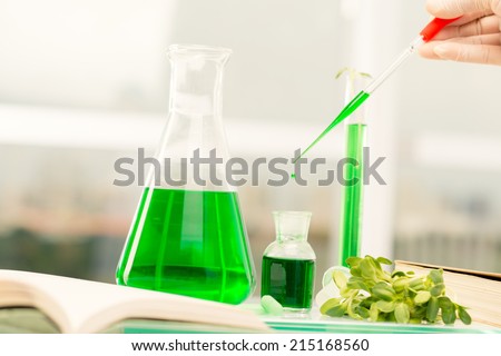 Hand of chemist measuring green extract of sprouts with pipette