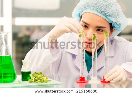 Young researcher putting sprouts into test tubes
