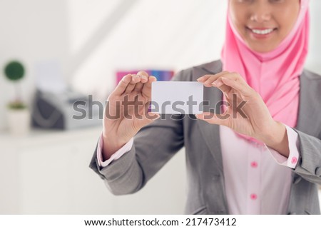 Cropped image of woman in hijab showing blank business card