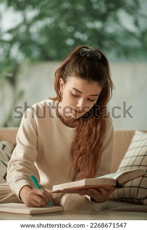 Similar – Image, Stock Photo Young woman doing homework on sofa