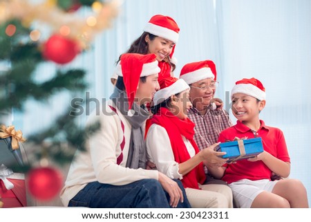 Happy Vietnamese family gathered together to exchange Christmas presents