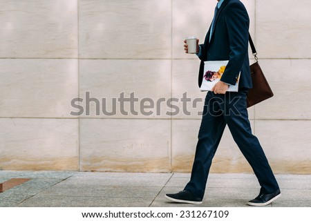 Cropped image of businessman with coffee and magazine going to work 商業照片 © 