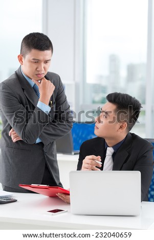 Serious managers discussing a document