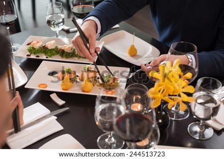 Cropped image of people eating appetizers at the restaurant