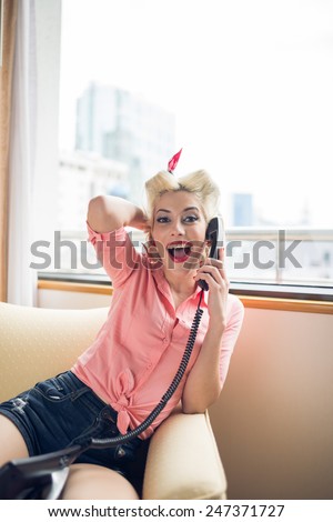 Portrait of lovely pin-up woman laughing and talking on the phone