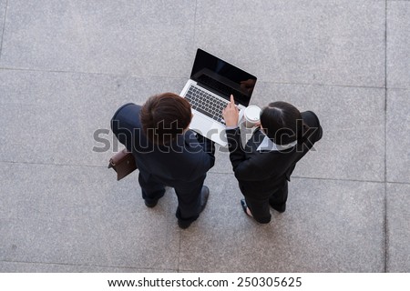 Business team working on laptop, view from the top