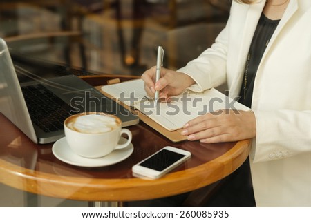 Cropped image of business lady working while sitting in the cafe