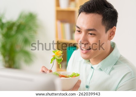 Young man eating vegetable salad
