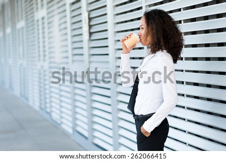 Asian business lady drinking coffee outdoors, side view