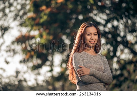 Portrait of pretty Asian young woman in the park