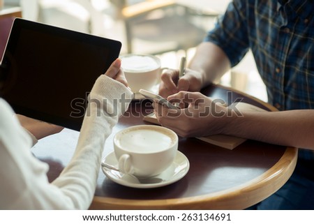 Business people using gadgets at the meeting in cafe