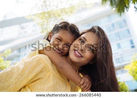 Happy hugging Indian mother and daughter