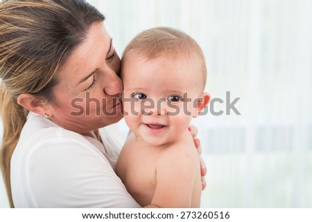 Close-up image of mother kissing her infant son