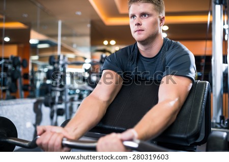 Strong man exercising with barbell in the sports club
