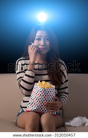 Crying young woman watching drama movie in the cinema