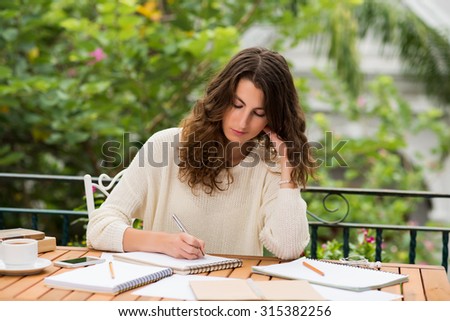 Portrait of pretty female journalist working on new article