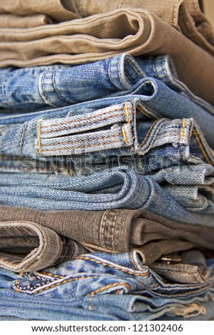Pile of jeans of various shades on a shop counter