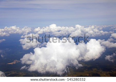 Plane view from the window on the clouds which are flying by over the earth