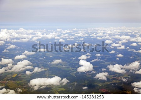 The clouds which are flying by over the earth. Plane view from the window