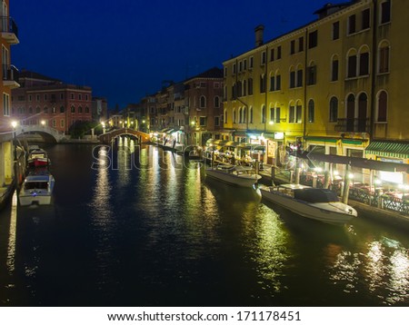 Venice, Italy, June 21, 2012 . Tourists spend the evening in a cafe on the canal bank