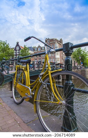 Amsterdam, Netherlands, on July 7, 2014. Bicycle on the bank of the channel. The bicycle is very popular type of transport in Holland