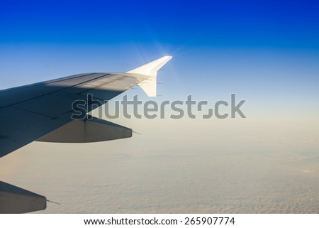 View of a wing of the plane and cloud from a window of the flying plane