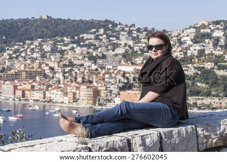 Vilfransh, France, on March 10, 2015. The happy woman is photographed against a beautiful landscape, the old city and the sea