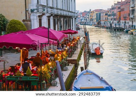 VENICE, ITALY - on MAY 1, 2015. Summer cafe on the bank of the Grand channel (Canal Grande). Numerous visitors sit at little tables
