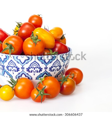 Cherry tomatoes of various grades in a bowl with a blue pattern