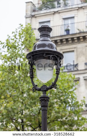 PARIS, FRANCE, on AUGUST 26, 2015. Typical architectural details of historical city building in rainy weather. Old streetlight.