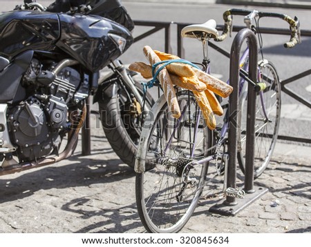 PARIS, FRANCE, on AUGUST 26, 2015. French baguettes on a luggage carrier of the old bicycle standing on a parking