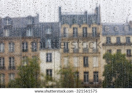 PARIS, FRANCE, on AUGUST 27, 2015. A fragment of skyline, a look through a wet window. It is raining, water drops on glass, focus on drops