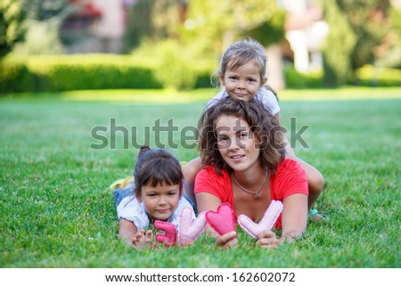 Happy Mother and two daughters portrait, with letters love in hands