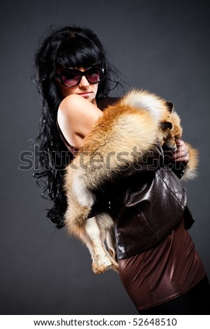 woman posing wearing leather jacket with fox fur
