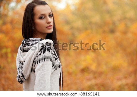 closeup beautiful woman looking around in autumn park