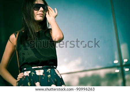 brunette  beautiful woman wearing glasses over glass wall